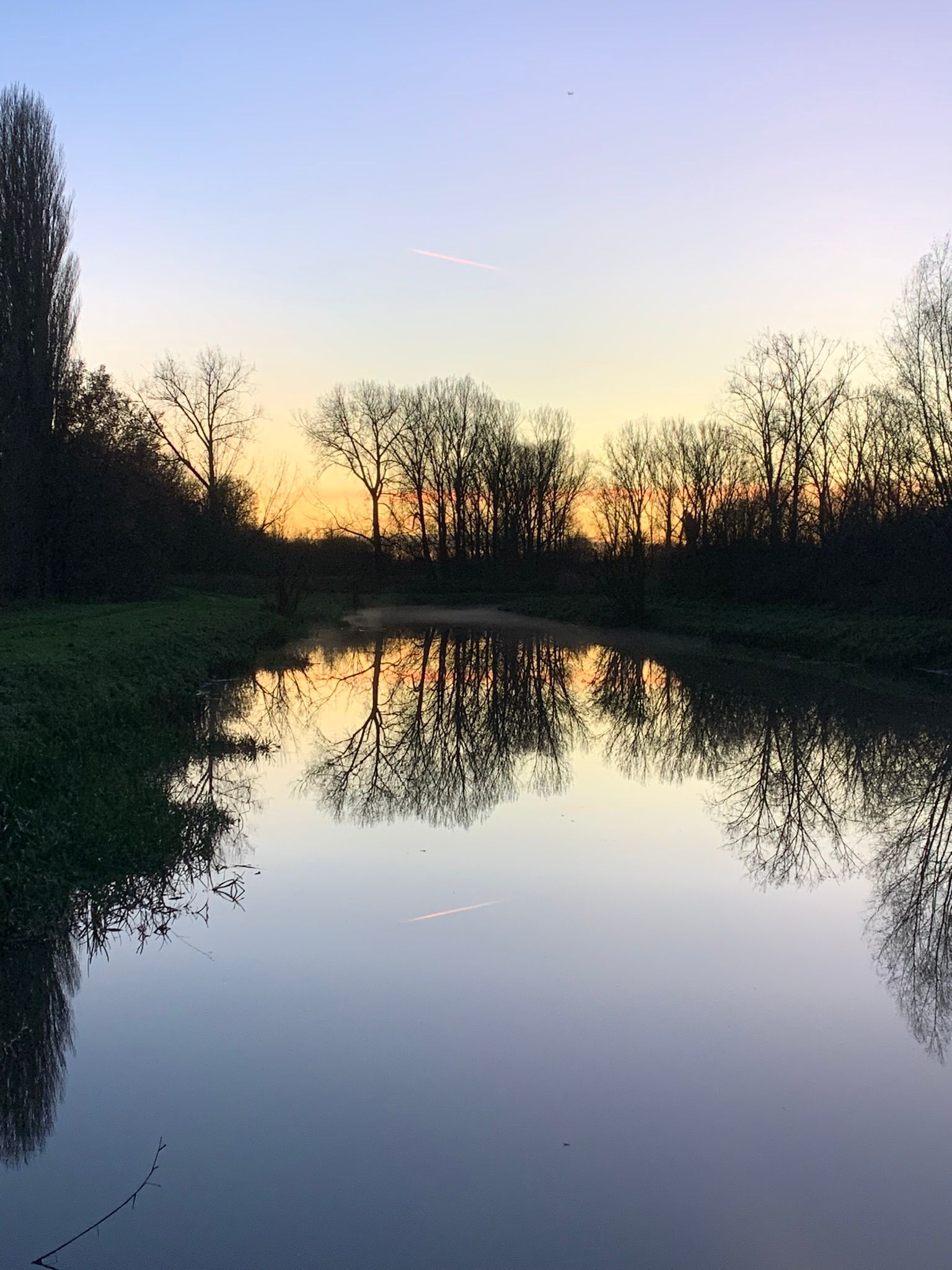 Tranquil lake at sunset with trees reflected in still water